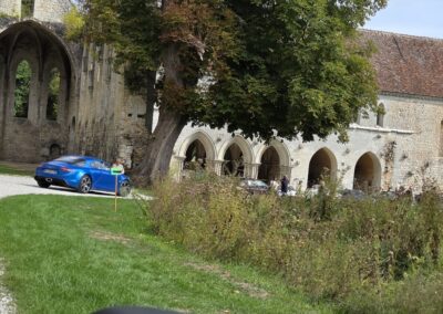 Alpine A110 devant les arcades de l’abbaye de Fontaine-Guérard